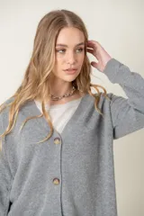 Cardigan celeste de lana con escote en V y botones marrones.