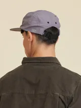 Gorro tipo trucker de gabardina color azul con visera plana y logo de la marca bordado en el frente.