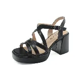 Sandalias de cuero sintético negro con plataforma y tacón cuadrado. Tiras cruzadas en el empeine y pulsera con hebilla ajustable al tobillo.