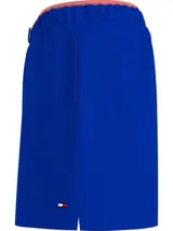 Bañador azul eléctrico de largo medio, con cintura elástica ajustable con cordón, ribete naranja en la cintura y logo de Tommy Hilfiger bordado en la parte trasera.