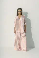 Camisa a rayas verticales blancas y negras, de corte recto y mangas largas.