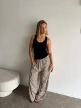 Pantalón ancho de tiro alto con elástico en la cintura y estampado animal print de leopardo en tonos beige y negro.