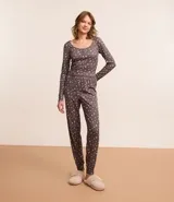 Conjunto de pijama largo de poliéster y elastano, color gris con estampado floral liberty. Incluye una blusa de mangas largas con cuello redondo y puños abotonados, y un pantalón con cintura elástica y puños ajustados.