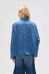Chaqueta de jean azul con cuello camisero, cierre frontal con lazos y bolsillos de parche.