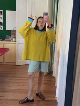 Buzo color marrón con cuello alto y mangas largas terminadas en volados.