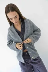 Cárdigan gris con botones frontales y diseño de corte relajado.