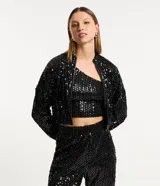 Campera bomber corta negra cubierta de lentejuelas metalizadas, con cuello alto, mangas largas, puños y bajo elásticos, y cierre frontal con cremallera.