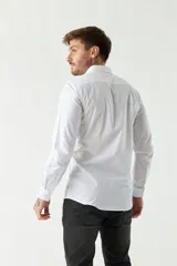 Camisa de vestir azul marino, de corte slim fit, manga larga y cuello clásico. Confeccionada en algodón y con logo bordado en el pecho.