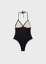 Traje de baño enterizo negro con escote halter, espalda descubierta, tirantes finos y aplique de crochet color crema en el corpiño.