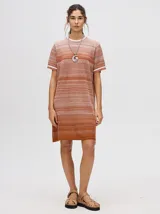 Vestido corto de tejido calado con cuello redondo y mangas cortas con puños a rayas en color contrastante. Diseño degradado en tonos lila y borgoña.