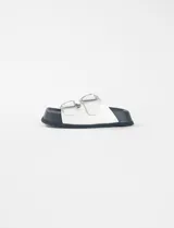 Sandalias blancas de cuero sintético con suela negra y hebilla plateada.