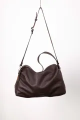 Cartera hobo de cuero color marrón oscuro, con correa de hombro y correa bandolera desmontable y ajustable. Tiene cierre metálico, bolsillo interior con cierre y bolsillo para celular.