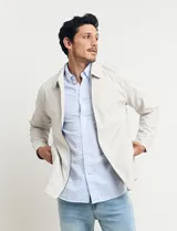 Campera de hombre color beige con cierre frontal, cuello camisero y bolsillos laterales. Corte clásico.