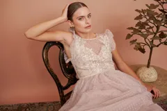 Vestido largo de fiesta color rosado con lunares blancos. Tiene cuerpo de micro tul bordado con volados en los hombros y falda de tul con forro. Incluye cinturón de raso al tono.