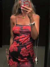 Minivestido de microtul con estampado de flores rojas sobre fondo negro.