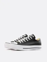 Zapatillas urbanas Converse Chuck Taylor All Star Lift, de cuero negro con plataforma blanca y cordones blancos.