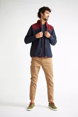 Campera polar para hombre, color azul marino con canesú y cuello en color borgoña. Tiene cierre frontal completo, bolsillos laterales con cierre, puños y ruedo elastizados, y logo estampado en el pecho.