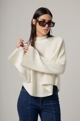 Sweater rojo de punto con cuello alto y mangas largas acampanadas.