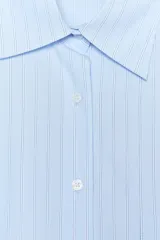 Camisa celeste con rayas verticales blancas, de corte amplio, cuello clásico, manga larga con puños abotonados, bolsillo de plastrón en el pecho y cierre frontal con botones.