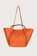 Bolso tote de cuero texturizado color naranja, con doble asa de mano marrón y tiras laterales delgadas que se anudan.