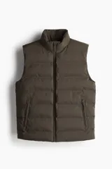 Chaleco puffer color verde oliva, con cuello alto y cierre frontal. Cuenta con bolsillos laterales con cierre y un bolsillo interno con botón a presión.