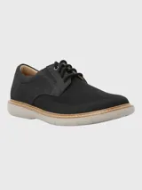 Zapato de vestir negro con capellada de cuero y tejido sintético, con cordones y suela de goma color crema.