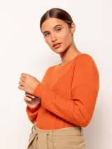 Sweater tejido color naranja de manga larga y cuello redondo, con detalles de tajo en los laterales.
