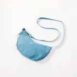 Bolso bandolera Nike Aura Crescent color celeste, con logo blanco estampado.