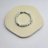 Pulsera elástica de cuentas esféricas de howlita mate color blanco con vetas grises.