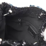 Bandolera negra cubierta de lentejuelas, con cadena plateada y cierre de broche. Forro interior textil y bolsillo interno con cierre.