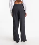 Pantalón de vestir gris oscuro, de corte recto, con bolsillos laterales y botón en la cintura.