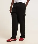 Pantalón baggy negro de algodón y poliéster, con cintura elástica ajustable con cordón, bolsillos laterales tipo cargo y bolsillo trasero.