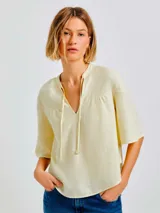 Blusa color amarillo claro de algodón con escote en V y mangas 3/4 acampanadas.