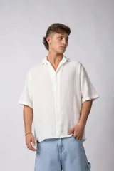 Camisa de lino color blanco, de manga corta, con cuello clásico y cierre frontal con botones.