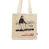 Bolso tipo tote de lona color crudo con asas de algodón. Estampado con dibujo de una persona paseando un perro y la frase "Pasos que valen la pena".