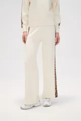 Pantalón de punto color crema, de corte ancho y tiro alto, con estampado animal print en los laterales.