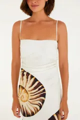 Vestido largo blanco con estampado de amonitas en tonos marrones. Diseño sin tirantes con tirantes finos, corte holgado y fluido.