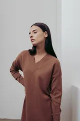 Vestido negro tejido con escote en V y corte recto. Largo hasta la rodilla con tajos laterales y detalle canalé en puños y ruedo.