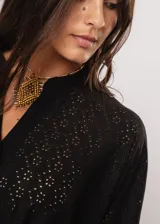 Camisa negra con calados, escote en V, abotonada y manga 3/4.