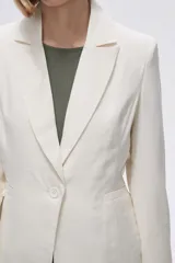 Blazer color crudo de rayon, entallado, con cuello solapa y cierre con un botón.