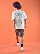 Remera blanca de algodón con cuello redondo y estampado frontal con el texto "Donald Duck" en color verde.
