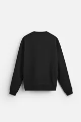 Sudadera negra de corte holgado, cuello redondo y mangas largas con puños acanalados.