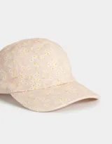 Gorra de béisbol color rosa con estampado de flores blancas y amarillas.