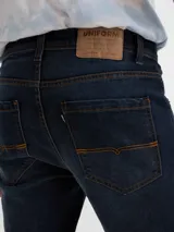 Jean slim de algodón, color azul profundo con corte ajustado.