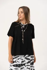 Blusa negra de corte holgado con mangas cortas.