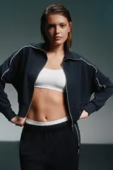 Conjunto deportivo azul marino con detalles de ribete blanco. Incluye una campera corta con cierre y un pantalón de corte recto.