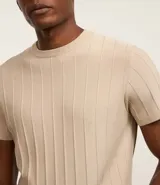 Remera de manga corta color marrón, con cuello redondo y textura acanalada vertical. Confeccionada en viscosa y poliamida.