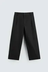 Pantalón negro de corte amplio, tipo balloon fit, con pinzas en la cintura, bolsillos laterales y traseros de ojal.