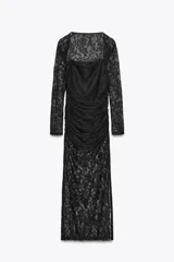 Vestido midi semitransparente de encaje negro, con escote recto, tirantes finos elásticos y mangas largas. Diseño drapeado en los laterales.