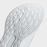 Championes de running Adidas Ultrarun 5, color blanco con detalles en rosado pálido en las tres franjas laterales y el talón. Presentan una suela gruesa y amortiguada.